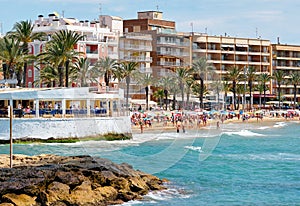 Lot of people sunbathing in Playa del Cura beach, Torrevieja, Spain