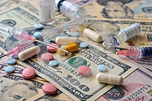 A lot of pills and capsules lie on the banknotes