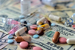 A lot of pills and capsules lie on the banknotes