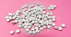 A lot of pills on pink background