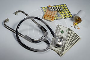 A lot of pills, a stethoscope and money on a table