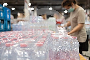 Lot of plastic packaging of fresh water,people wearing face mask,choosing fresh water,beverage and food,woman panic buying and