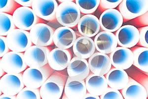 A lot of plastic pipes. The pipes are red outside and blue inside. Warehouse production