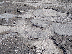 A lot of potholes on one small piece expensive asphalt