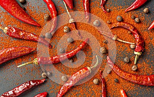 A lot of red and green pepper and pepper. Sprinkle paprika on a black background, top view