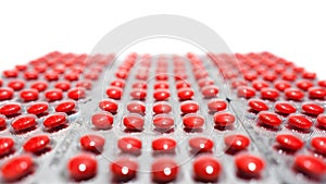 A lot of red round tablets in a packs in a row. Pharmaceuticals and pills on a white background. Space for copy and  text