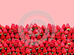 A lot of ripe strawberries with space for text on a red background. The concept of healthy food