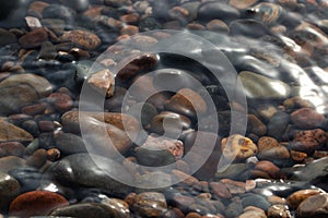 A lot of rocks on the background of water. River bank. Clean water. Clean beach for relaxation. Environment, ecology.