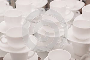 a lot of rows of pure white cups with plates for coffee or tea break . High quality photo