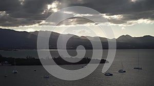 A lot of sailboats in a calm water with mountain and clouds on background near Guadalupe island