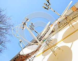 A lot of satellite dishes mounted on the wall.