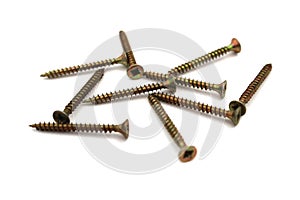 A lot of self-tapping screws lie on a white isolated background.