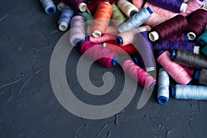 A lot of sewing colored thread. Thread reels. Colorful threads in the box. Texture of sewing accessories