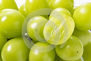 A lot of Shine-Muscat grapes and cut Shine-Muscat grapes on a white background