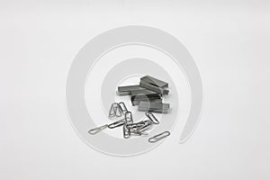 a lot of silver new staples for stapler and paperclips isolaon white background