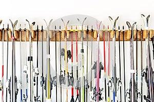 Lot of ski hanged on customized wooden wall mount at garage for seasonal storage. Extreme winter sport equipment handling at home