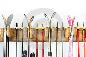 Lot of ski hanged on customized wooden wall mount at garage for seasonal storage. Extreme winter sport equipment handling at home