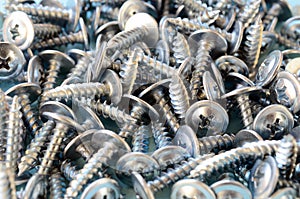 A lot of small silver screws are in a big chaotic pile