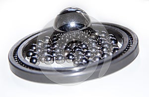 A lot of small stainless balls mirroring in one big stainless ball within a slim ball bearing