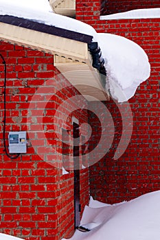 A lot of snow lies on a residential building and large snowdrifts around