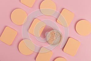 A lot of sponge, a beautiful blender for applying foundation or powder. Flat lay on a pink background, copy space