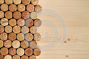 A lot of wine corks on the wooden background close up, top view.