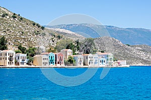 A lot of tiny colorful houses on the rocky shore of Mediterrenean sea on Simy greek island