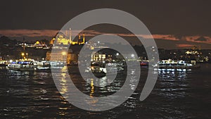 A lot of tourist ships and boats in Golden Horn with view to Suleymaniye Mosque on a nigtfall sky, Istanbul Turkey. 4K