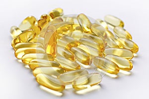 A lot of transparent yellow capsules on a white background.