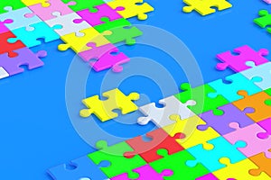 Lot of unfinished colorful puzzle jiggle pieces on blue background