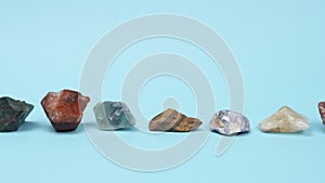 Lot unprocessed natural stones on a blue background.