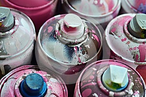 A lot of used spray cans of paint close-up. Dirty and smeared cans for drawing graffiti. The concept of a sweeping and careless d