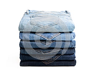 Lot of various used women jeans stacked in a pile isolated on white