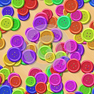 Vibrant colored vintage clothing plastic buttons randomly scattered on the wood background - top view