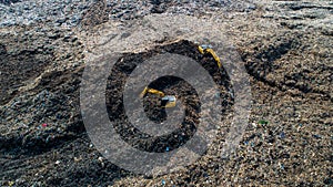 A lot of waste is disposed of in the waste disposal pits. Loaders is working on a mountain garbage. Aerial view and top view