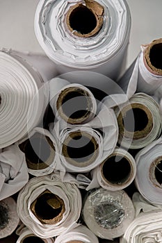 Lot of white textile rolls in a tailors studio