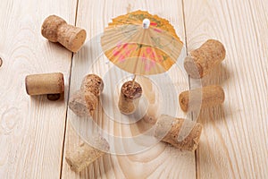 A lot of wine corks on wooden boards, a cocktail umbrella sticking out of cork, a holiday concept