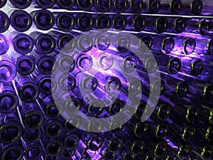 lot of wine glass bottles on a wall and indirect light in purple color, background and texture