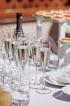 A lot of wine glasses with a cool delicious champagne or white wine at the bar. Alcohol background.