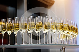 A lot of wine glasses with a cool delicious champagne or white wine at event