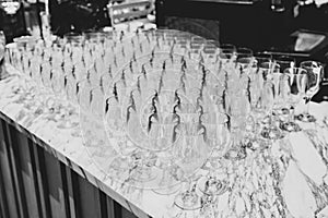 A lot of wine glasses in a row .Empty clean glasses standing in a row on a table prepared by the bartender for champagne and wine
