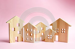 A lot of wooden houses on a pink background. The concept of the city or town. Investing in real estate, buying a house. Management