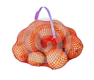 A lot of yellow onion in a red mesh packaging with a handle. Prepacked vegetables in store mesh package. Isolated on white