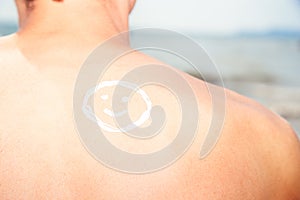 Lotion man with sunscreen smiley above sea