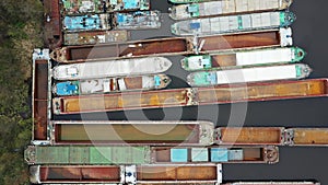 Lots of abandoned transport barges moored side by side at the wharf. River transport industry.