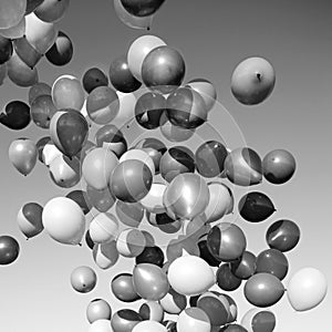 Lots of balloons flying in the sky. monochrome, black and white