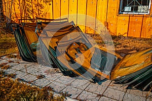 Lots of broken windshields for different cars in the junkyard.