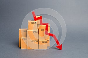 Lots of cardboard boxes and a red arrow down. Concept drop in industrial production, sales fall. economic downturn photo