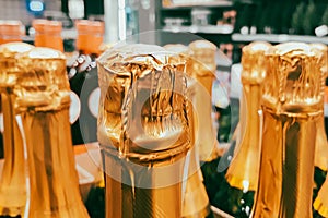 Lots of champagne bottles in store. Sale of alcoholic beverages before holiday. Close up of bottlenecks.