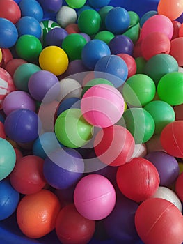 lots of colorful balls that are collected together in a container